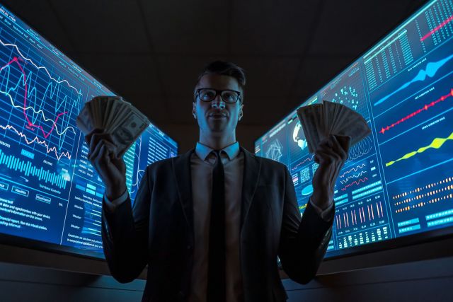 The smiling businessman holding dollars in his hands